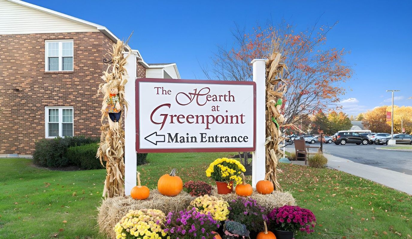 Main entrance sign of Hearth at Greenpoint with seasonal decorations