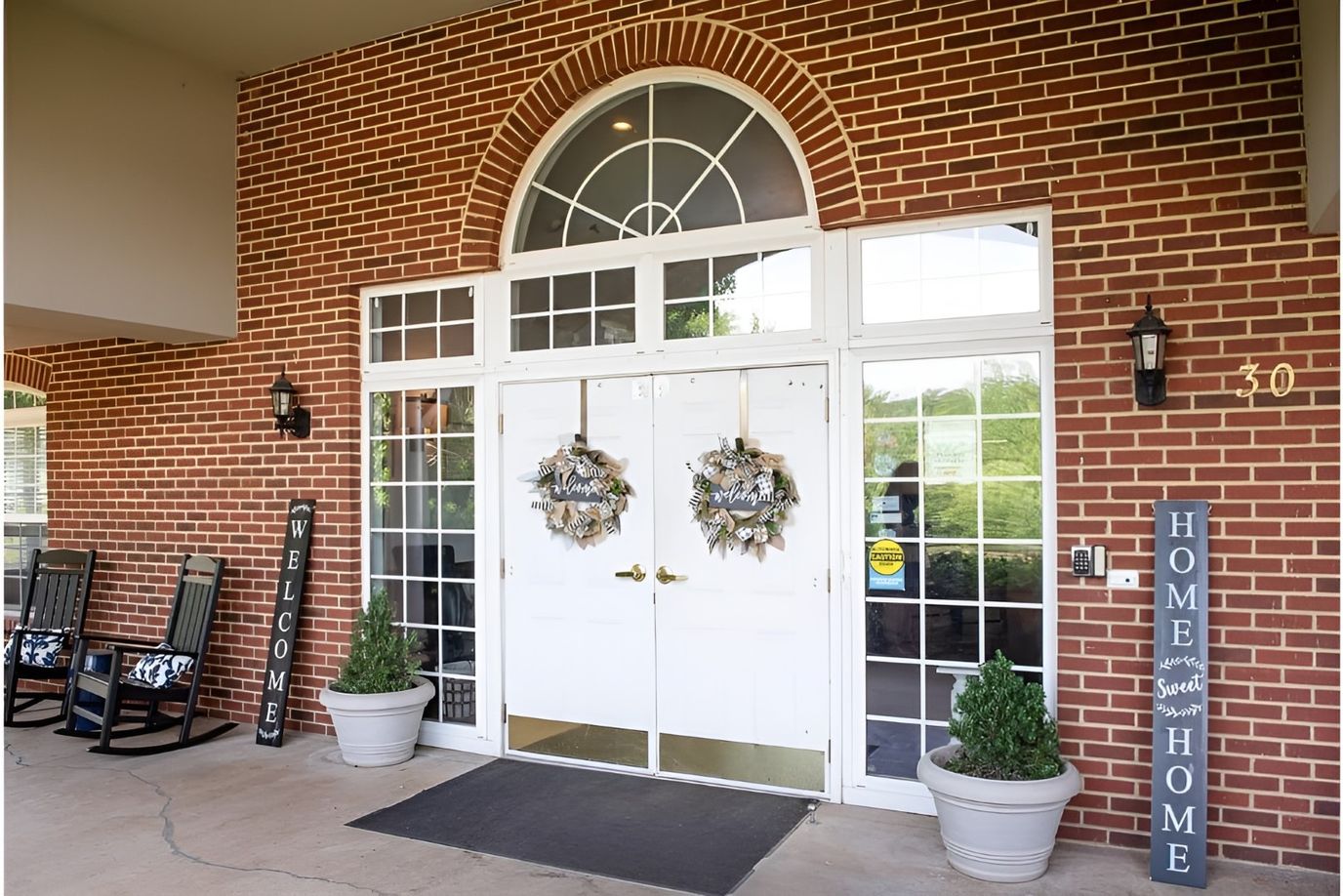 Entrance of a senior living facility with wreaths and welcoming signs