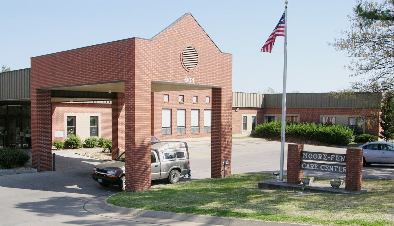 Exterior view of Moore-Few Care Center with entrance and flag