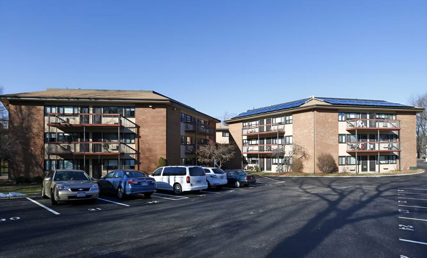 Exterior view of a senior living facility with parking area