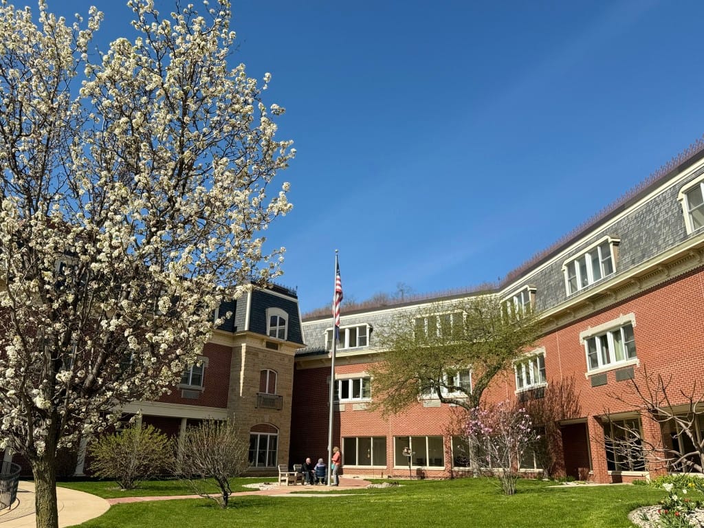 Exterior view of a retirement center with flowering trees