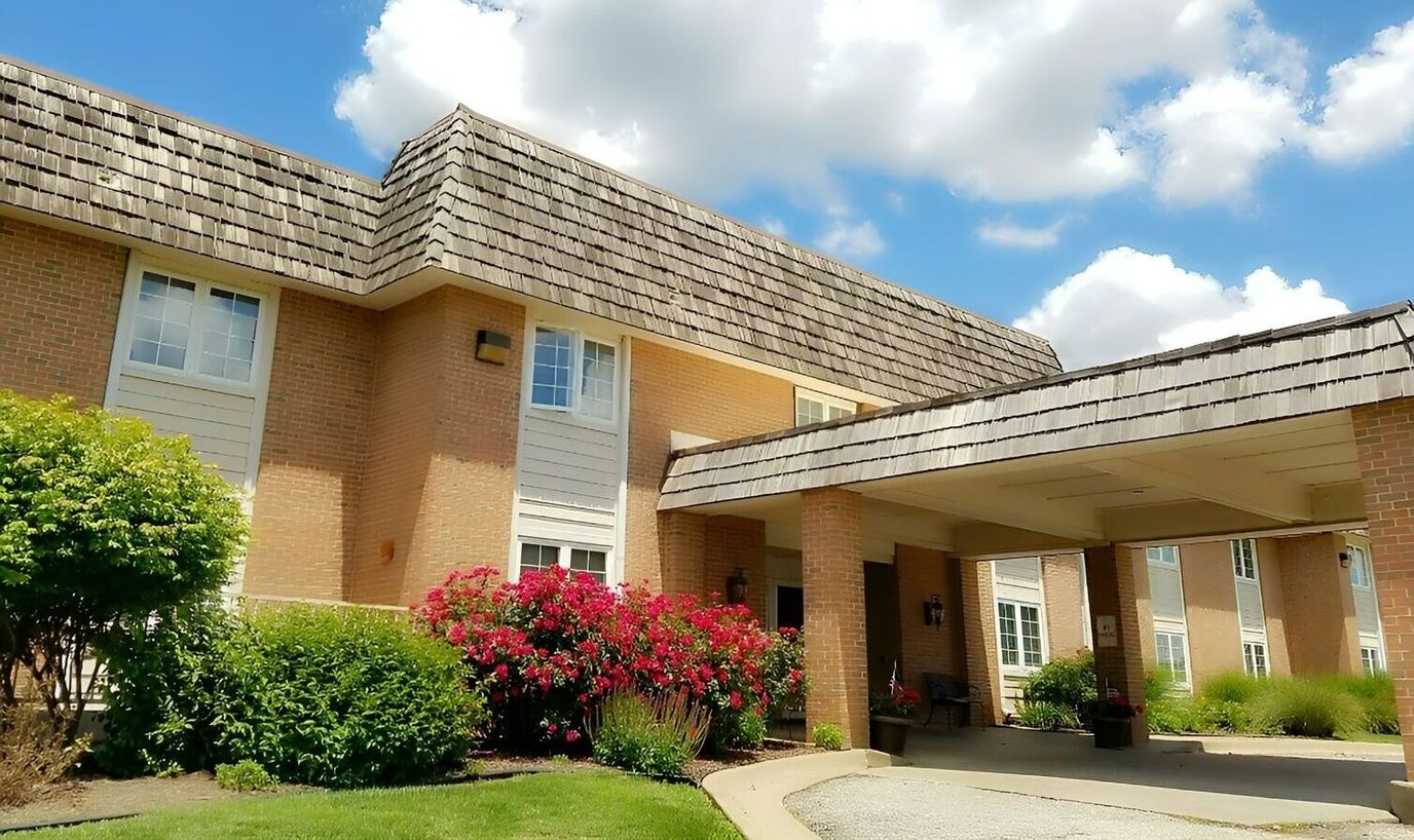 Exterior view of Arbor Court Retirement Community with flowers