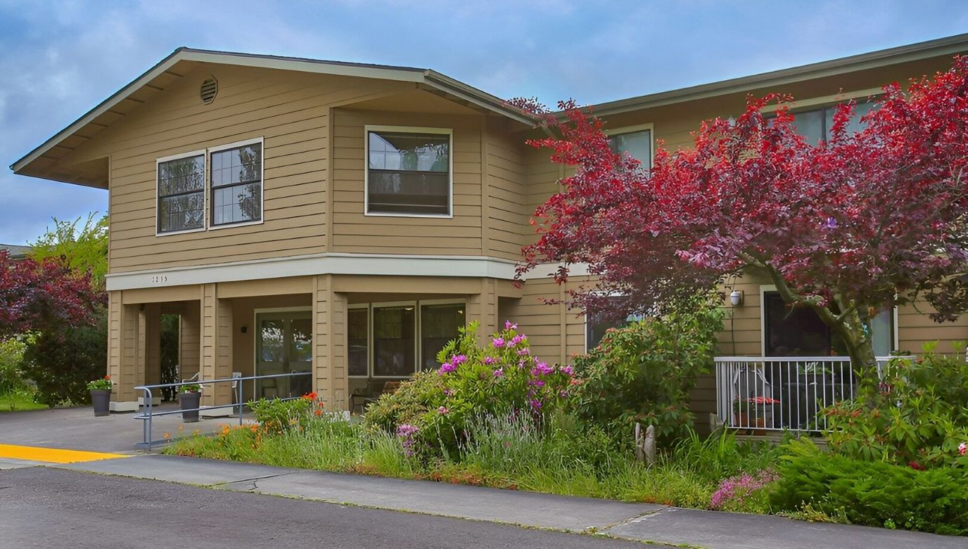 Exterior view of a senior living facility with colorful landscaping
