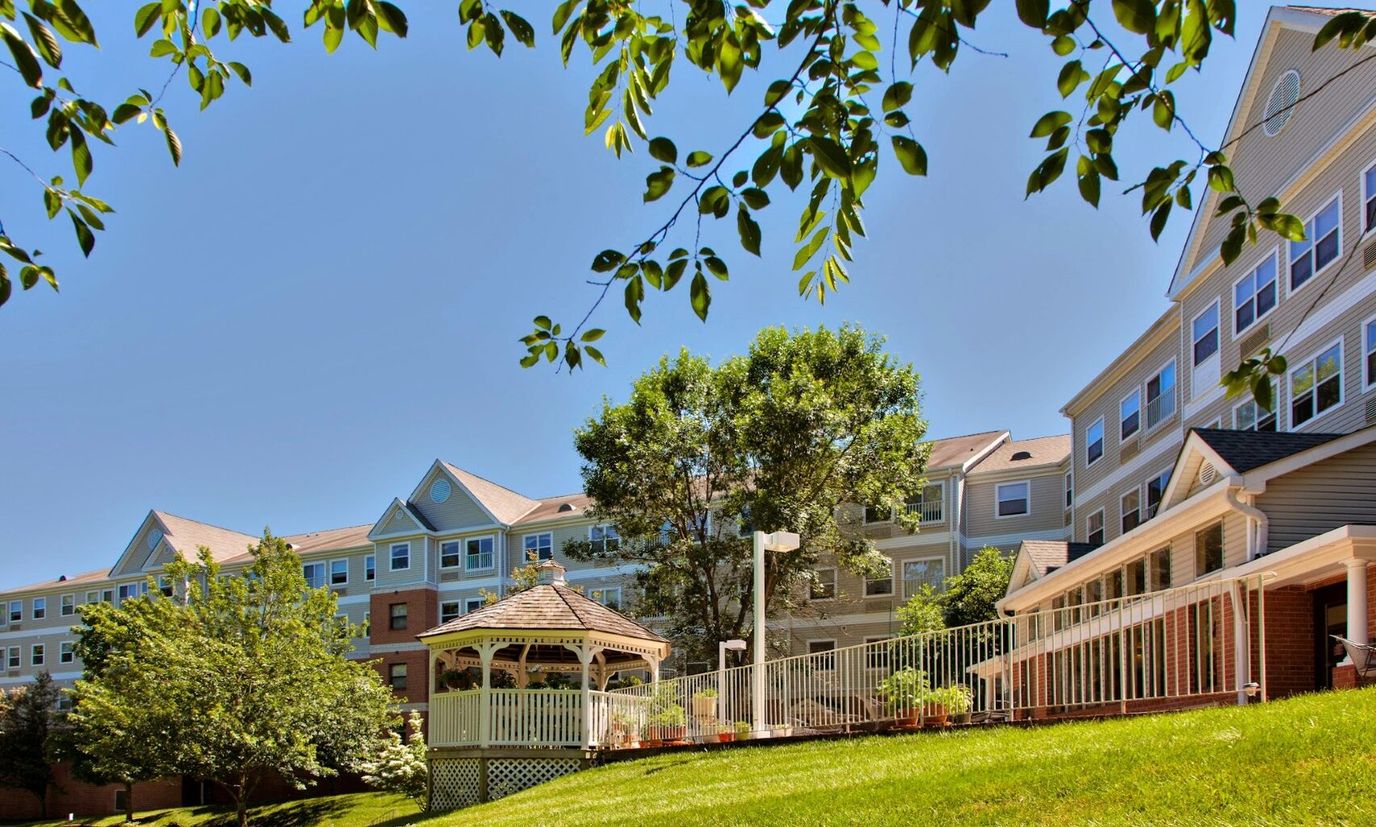 Exterior view of a senior living facility with outdoor gazebo