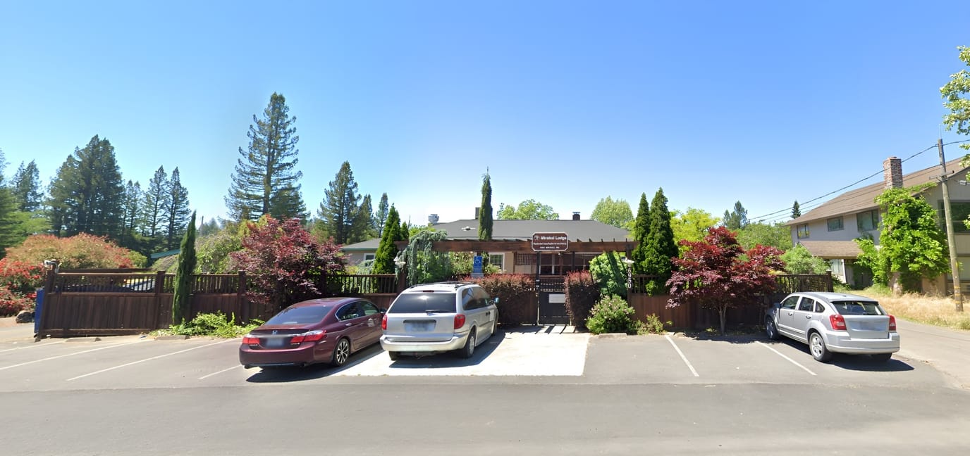 Front exterior of Mirabel Lodge with parking area
