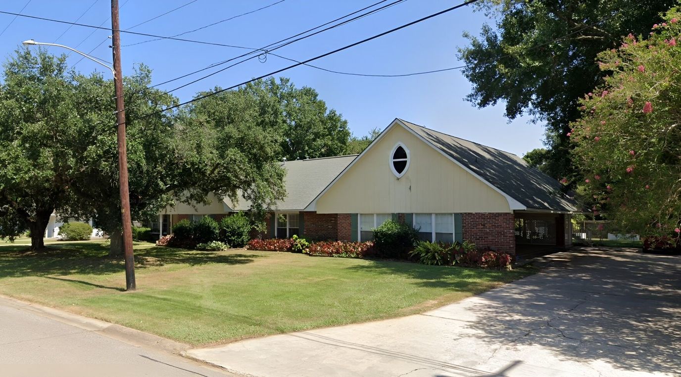 Exterior view of assisted living facility with landscaped yard