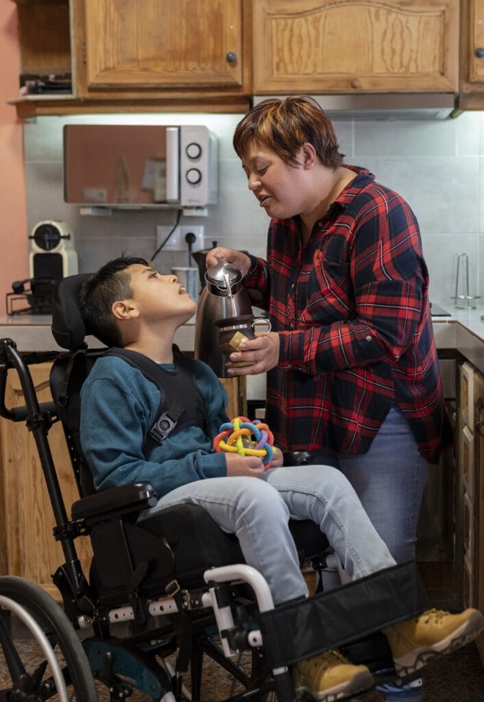 Caregiver assisting a child in a kitchen