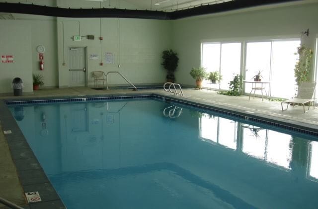 Indoor pool area with natural light and seating