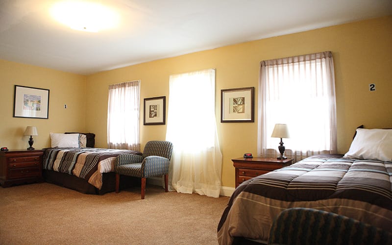 A cozy shared room with two beds and lamps