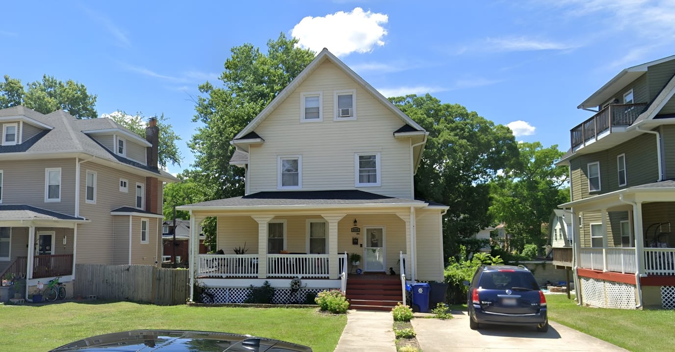 Exterior view of a beige house with a porch