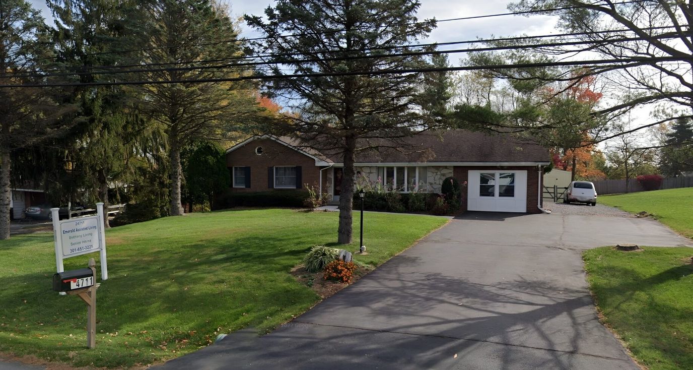 Exterior view of a senior living facility with green lawn