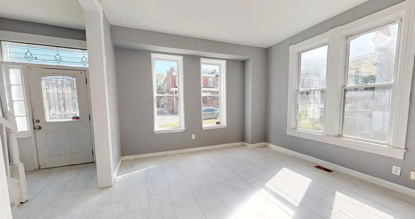 Bright, spacious living room with windows and tiled floor.