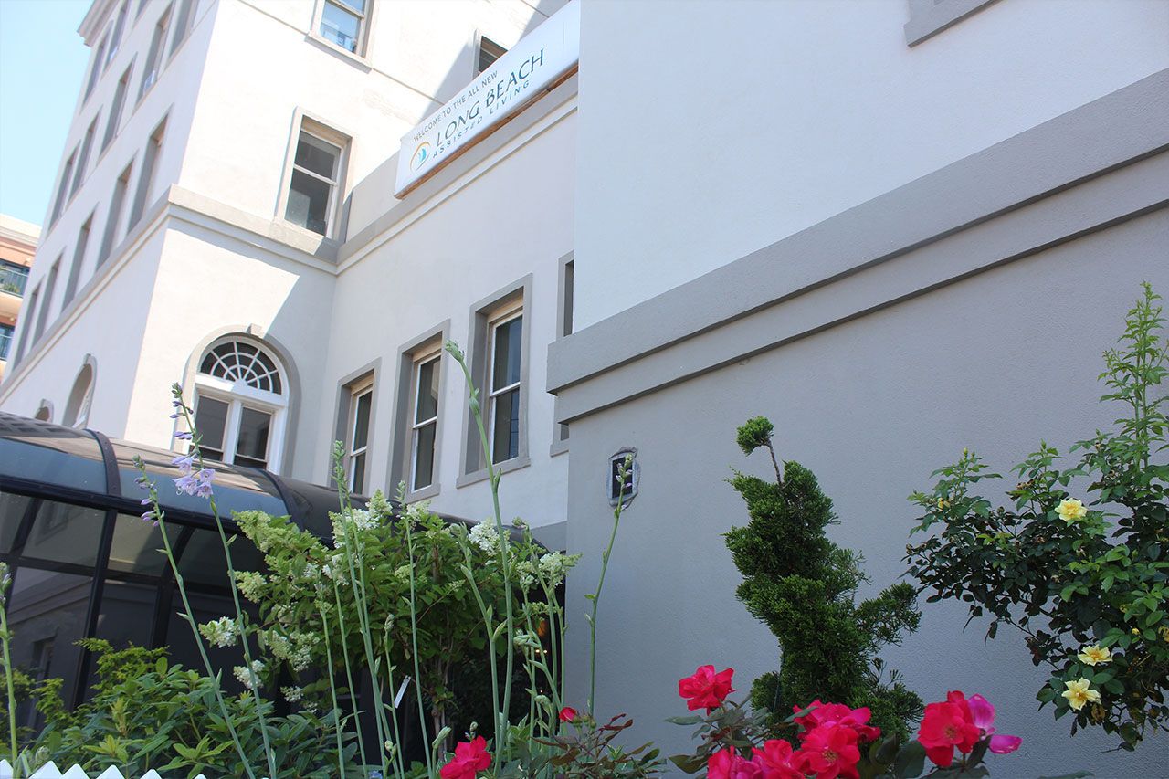 Exterior view of Long Beach Assisted Living with garden flowers