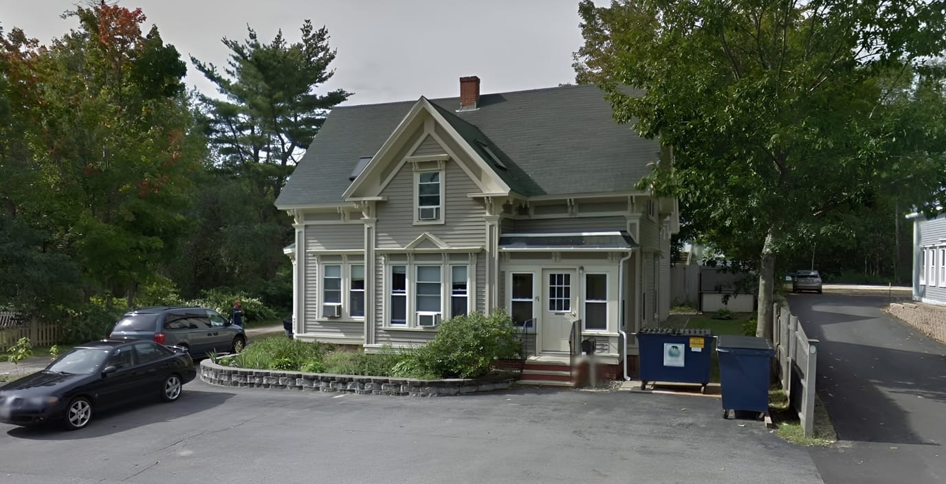 Exterior view of a charming home with gardens and parking