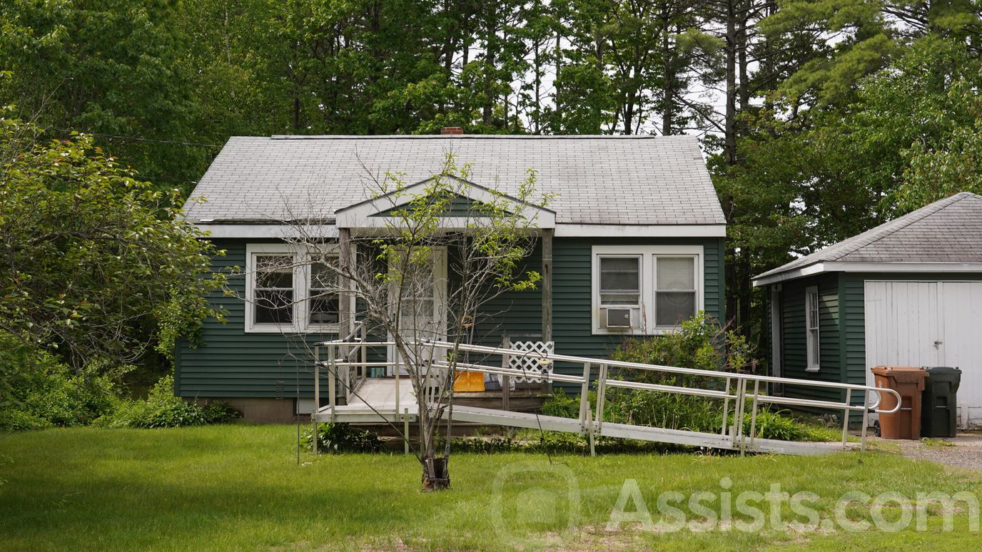 Exterior view of a green house with a ramp