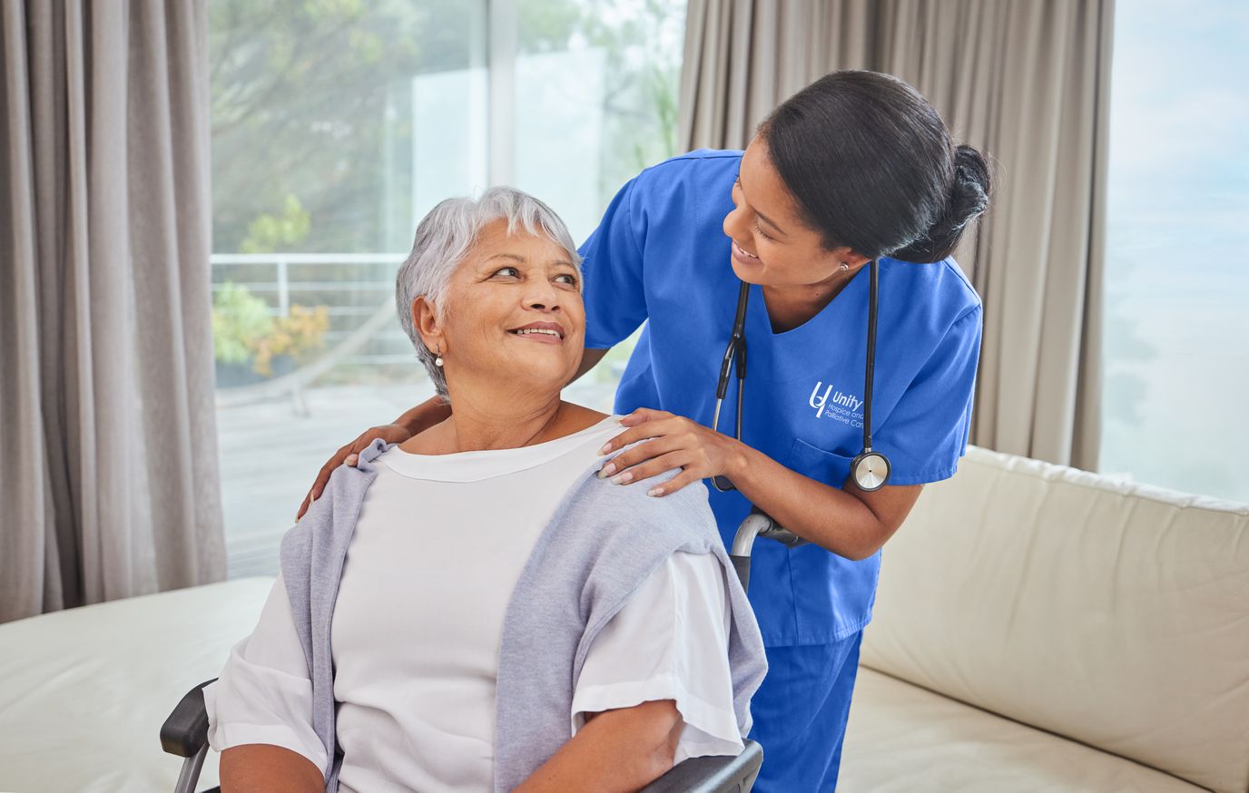 A nurse interacting with an elderly resident in a comfortable living area.