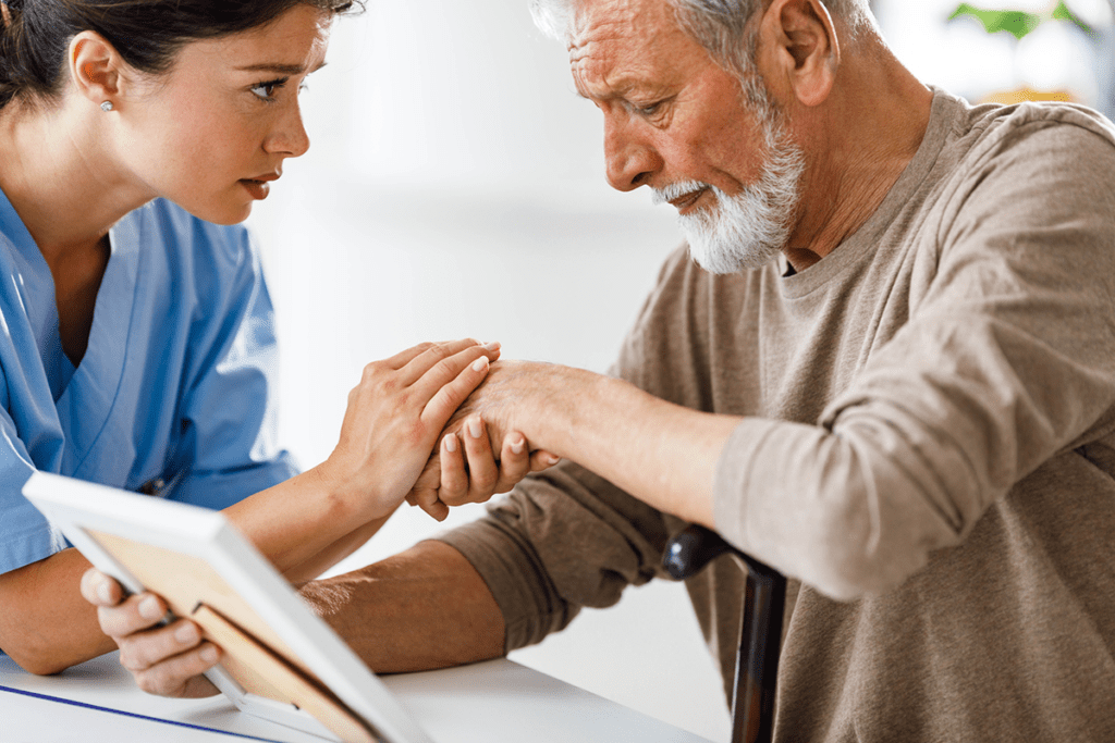 Caregiver gently interacts with elderly man.