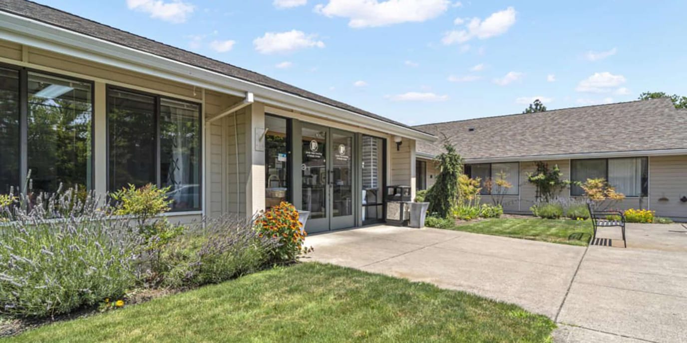 Exterior view of a senior living facility with gardens