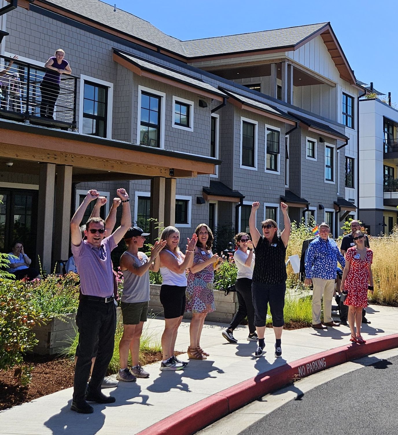 Residents and staff celebrating outside the facility.