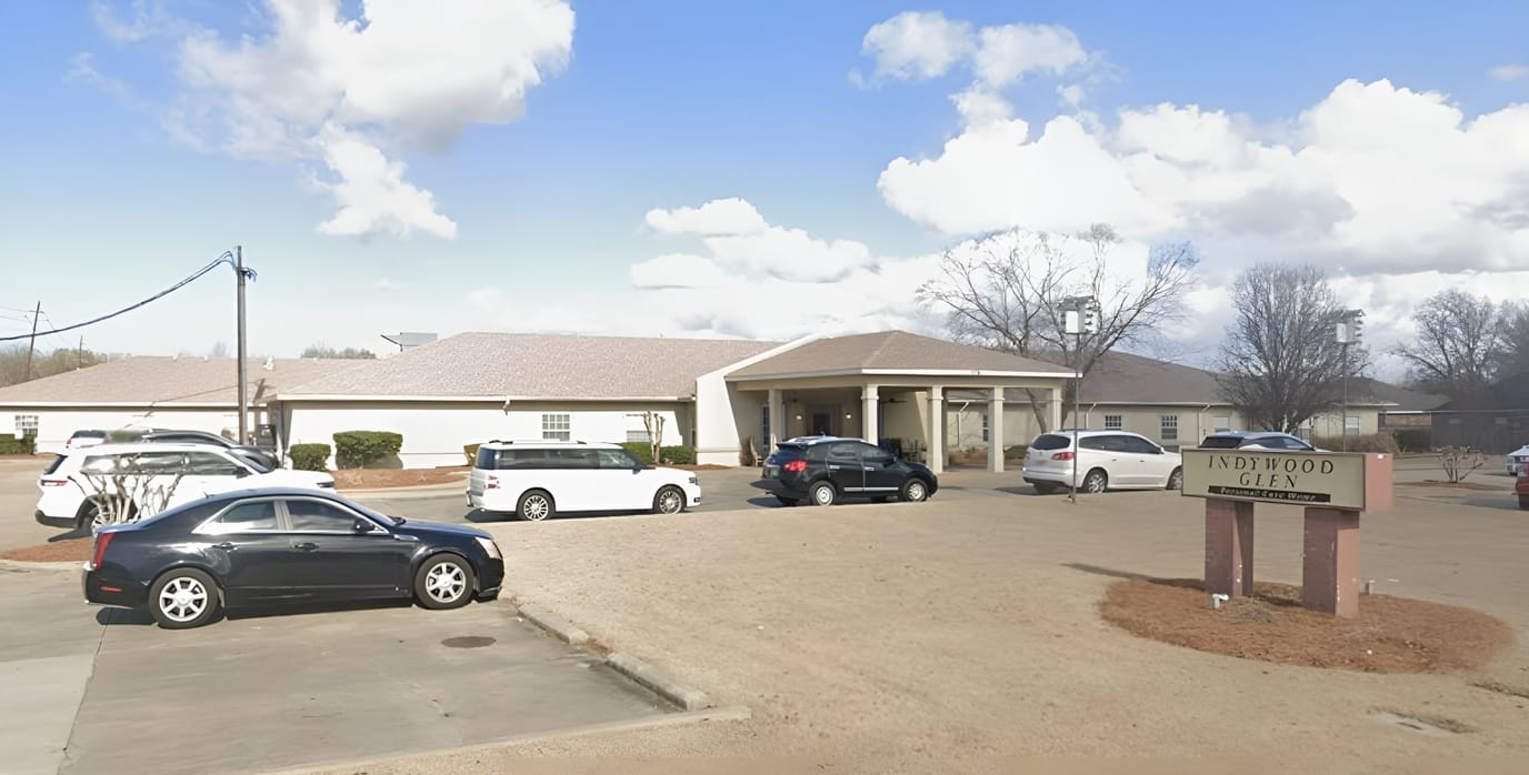 Exterior view of Indywood Glen assisted living facility with vehicles