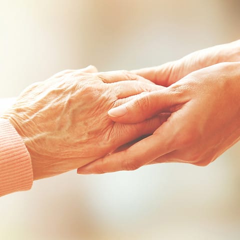 Two hands holding each other warmly