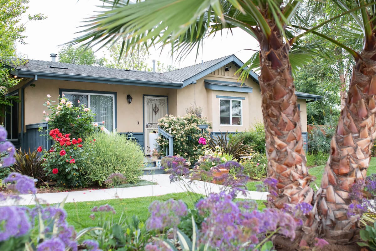 Exterior view of a cottage surrounded by flowers