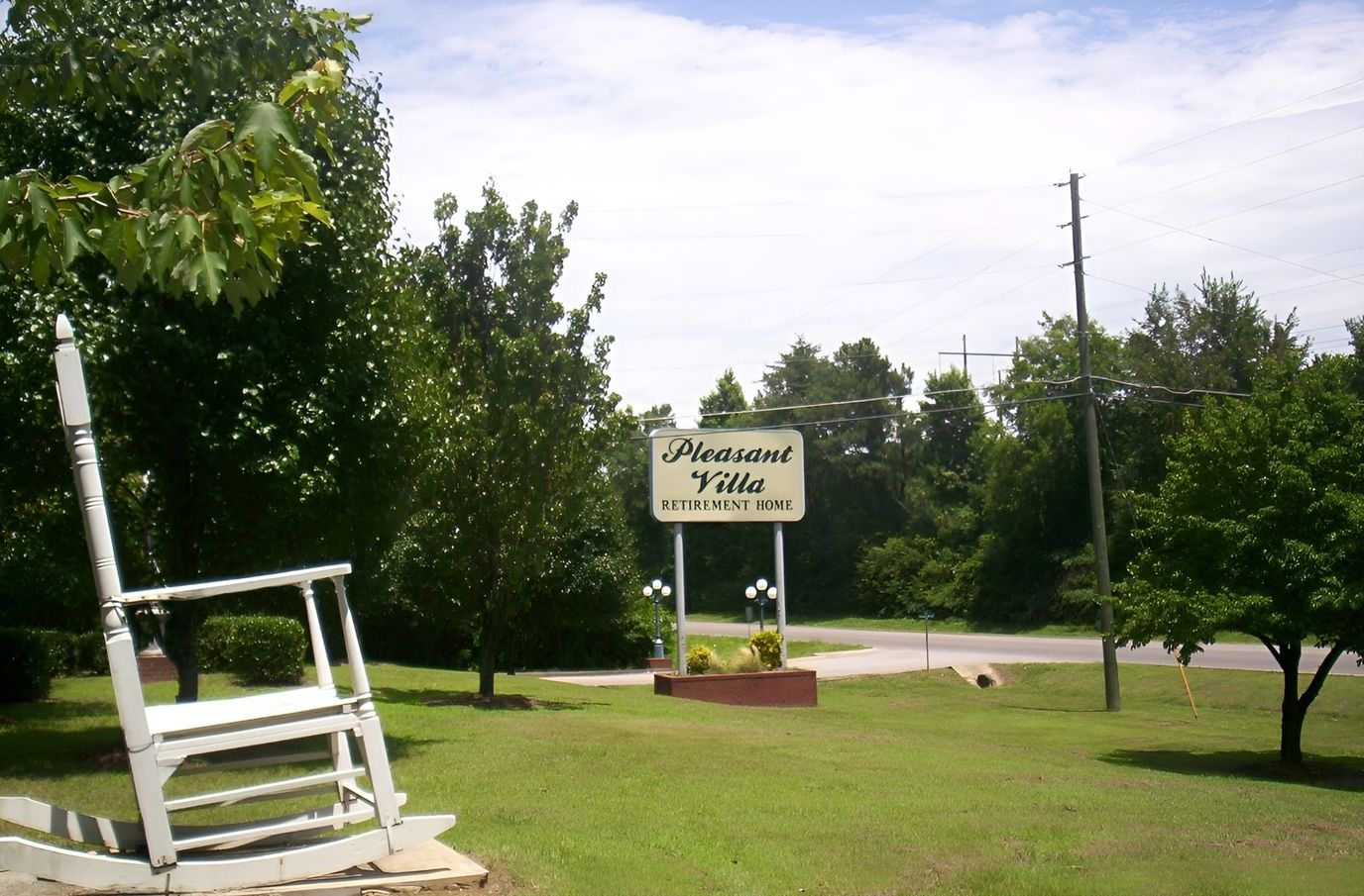 Exterior view of Pleasant Villa Retirement Home sign with rocking chair