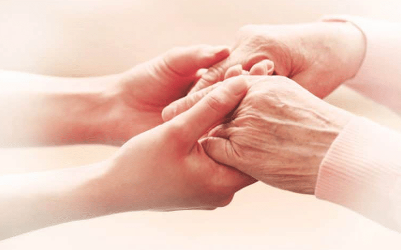 Pleasant View, Nursing Home in Owosso, MI — Hands of a caregiver and a senior citizen holding each other
