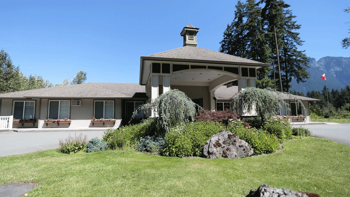 Exterior view of Riverside Manor surrounded by greenery.