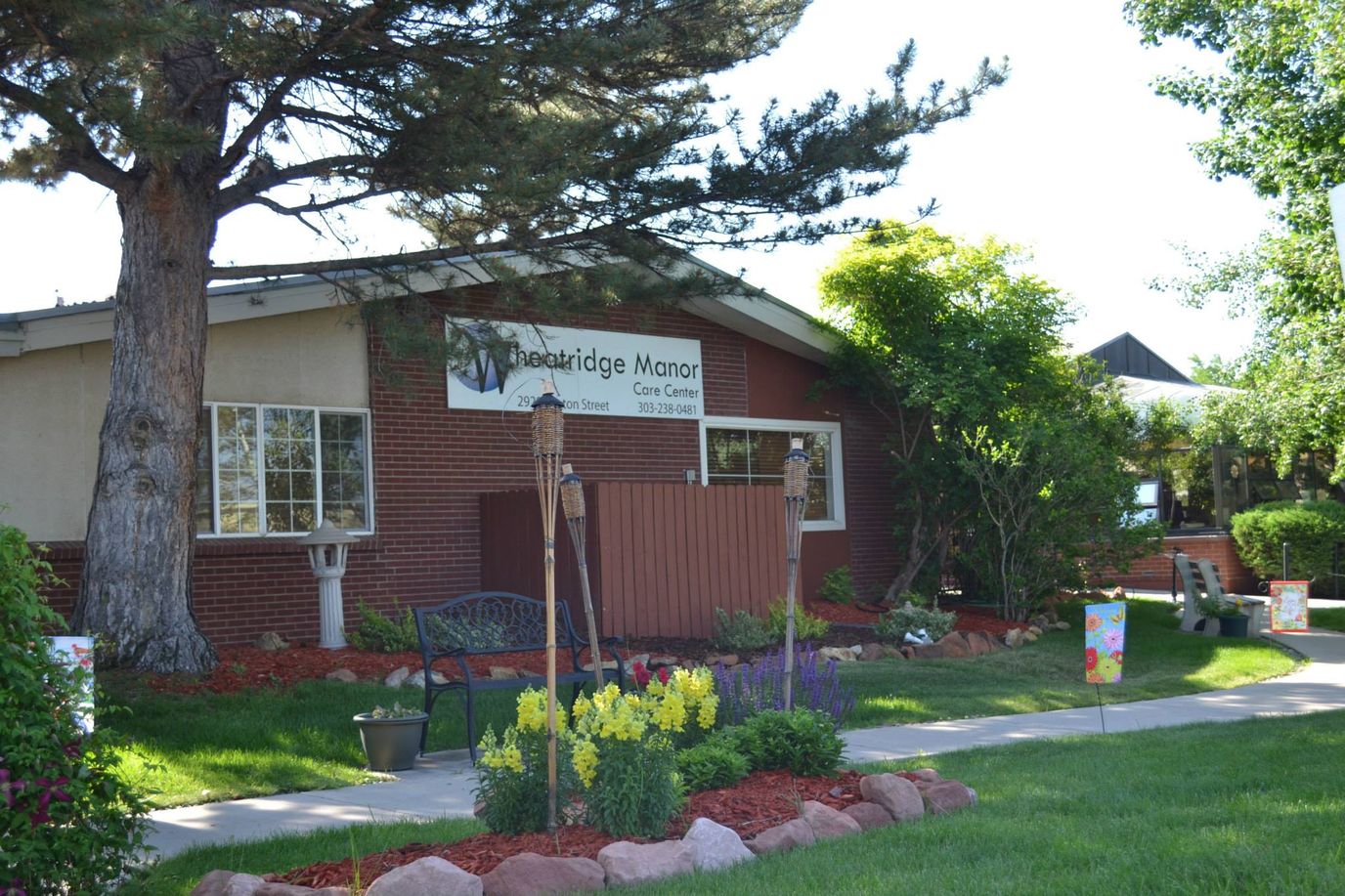 Exterior view of Wheatridge Care Center with landscaping