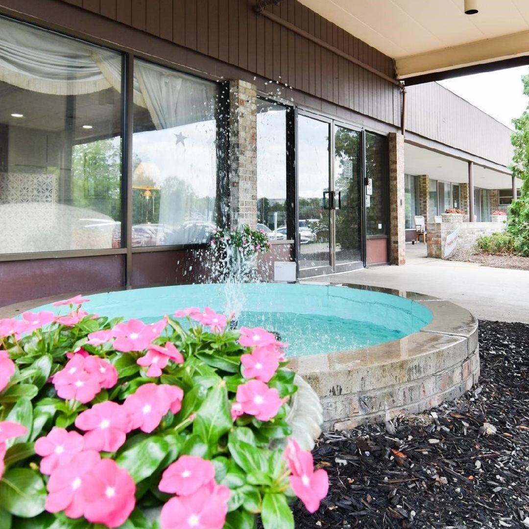 Outdoor fountain with flowers in front of the facility