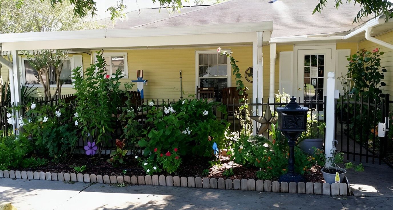 Well-maintained outdoor entrance with flowers and fence