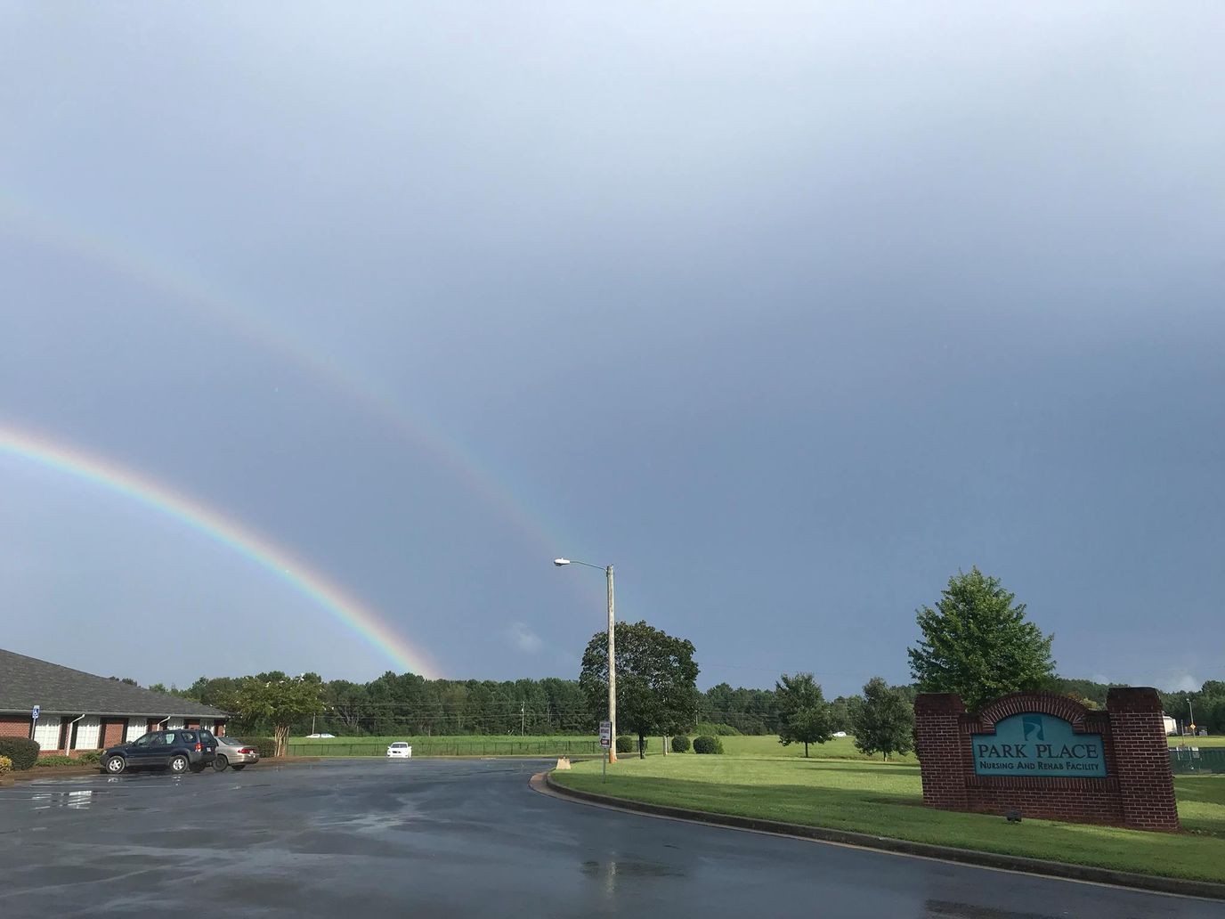 Exterior view of Park Place Nursing and Rehab Facility with a rainbow