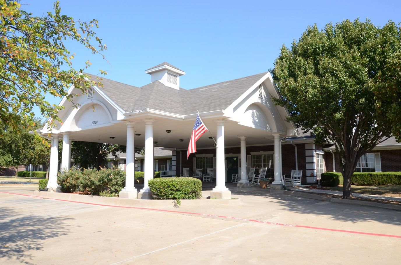 Front entrance of Victoria Gardens of Frisco with columns and American flag