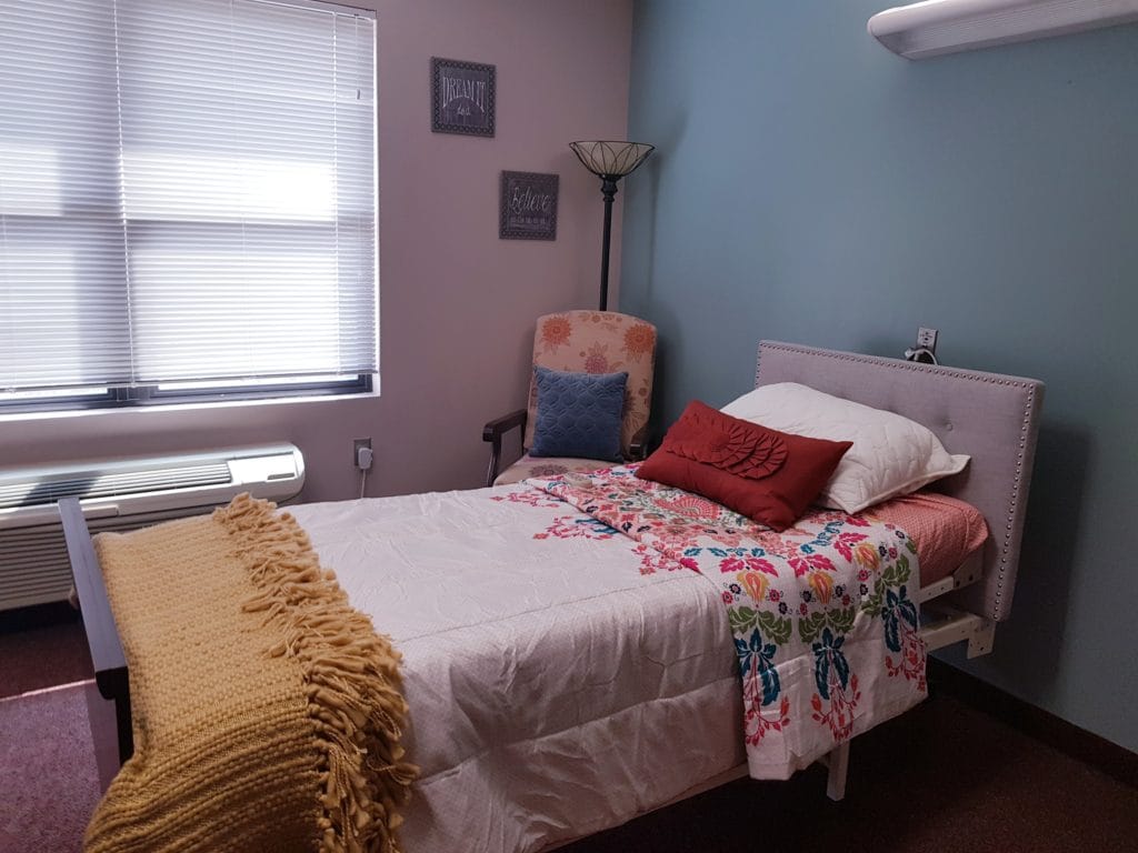 Cozy resident room with bed and decorative pillow