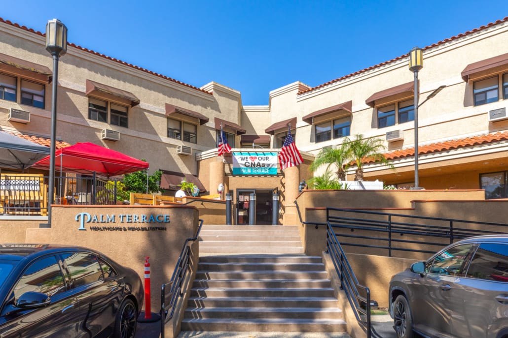 Front entrance of Palm Terrace Healthcare with flags and signage