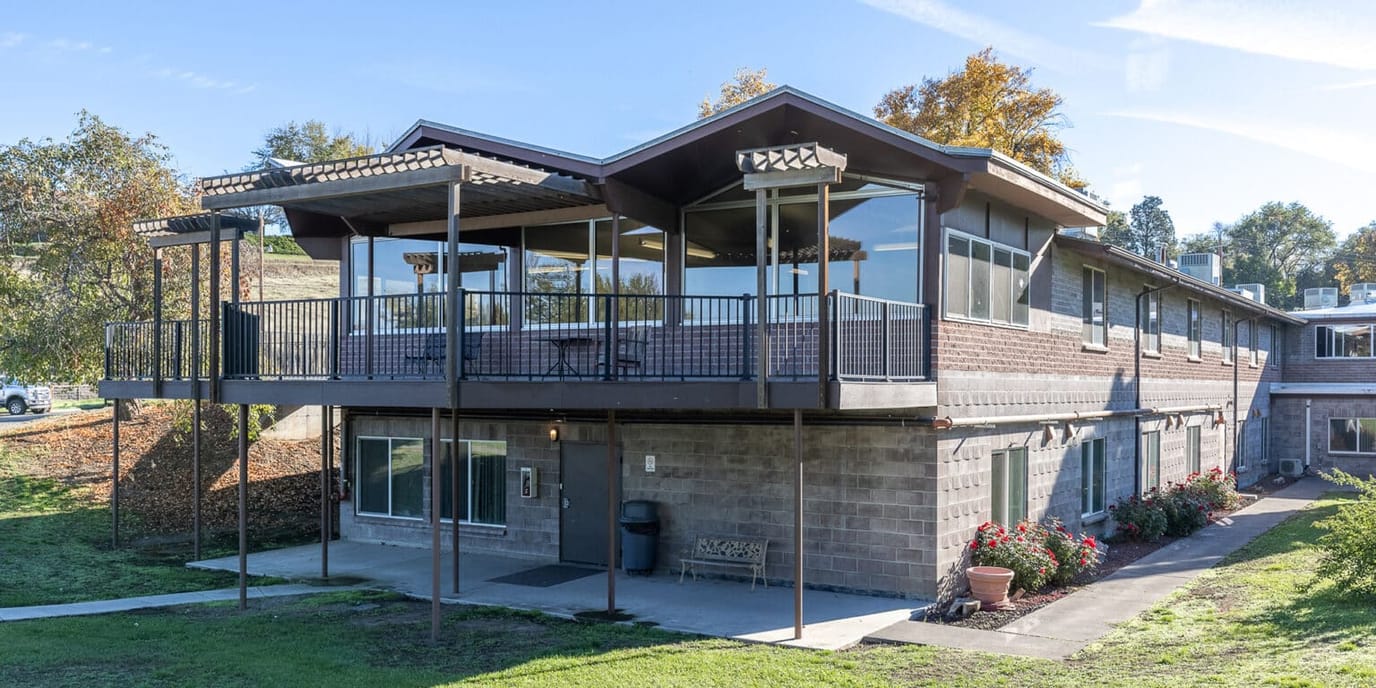 Exterior view of a senior living facility with outdoor seating