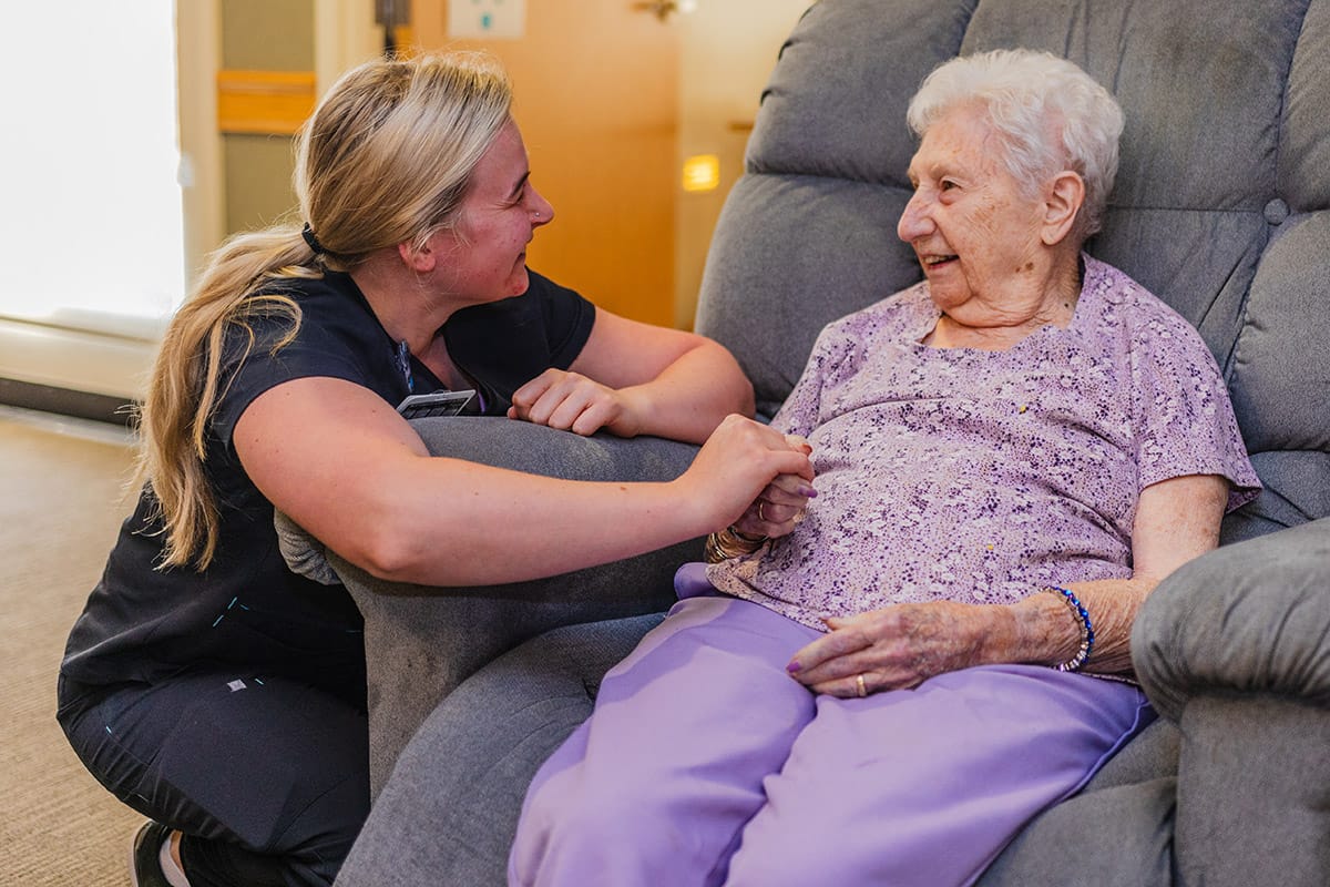 Staff interacting with a resident in a comfortable setting.