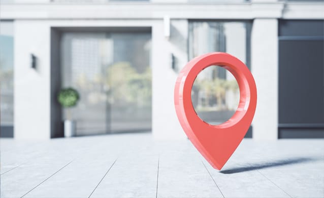 A large red location pin in a modern outdoor space