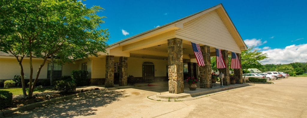 Exterior view of a senior living facility with flags