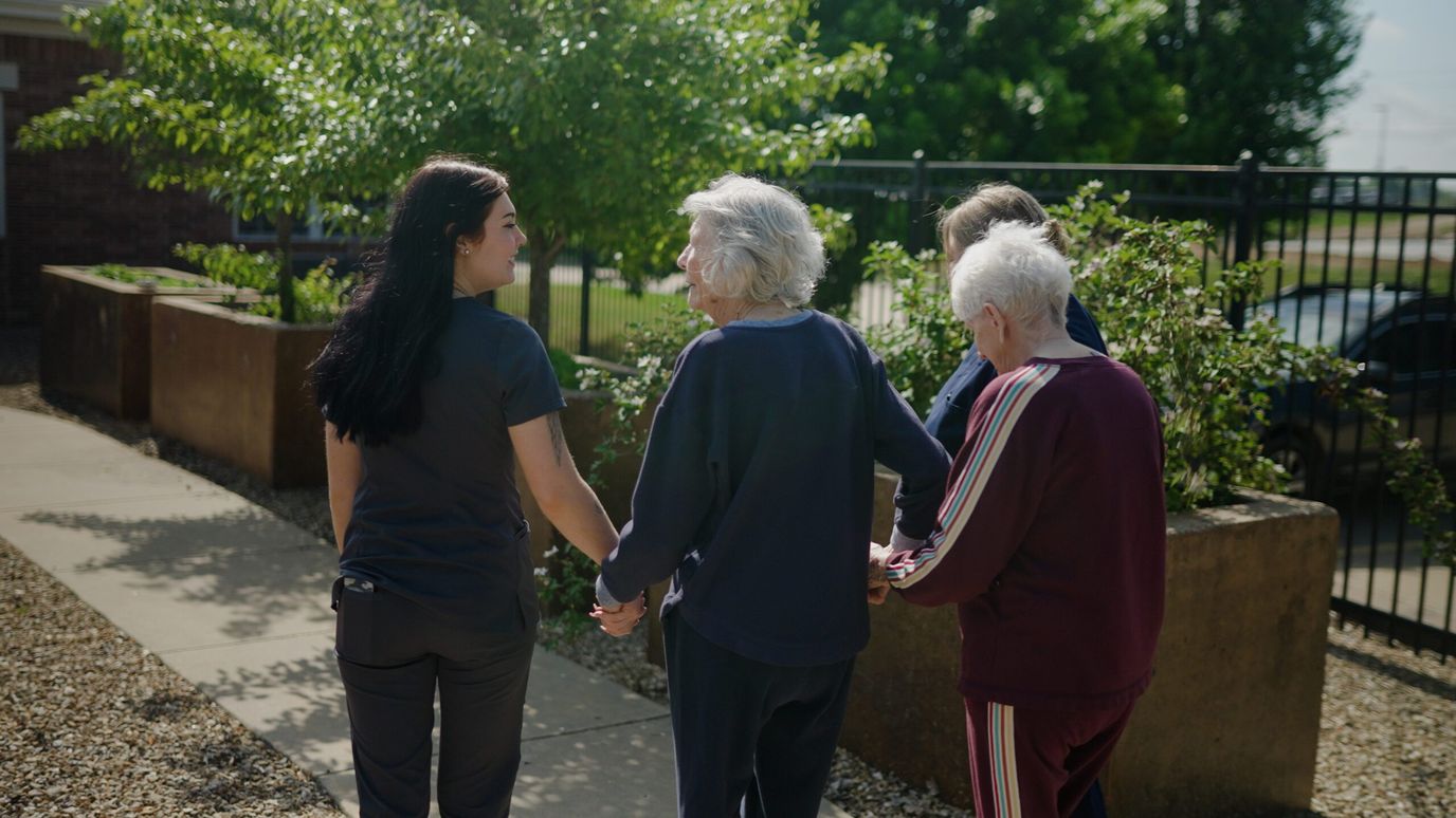 The Maples at Har-Ber Meadows, Nursing Home in Springdale, AR — Staff assisting residents in an outdoor garden area