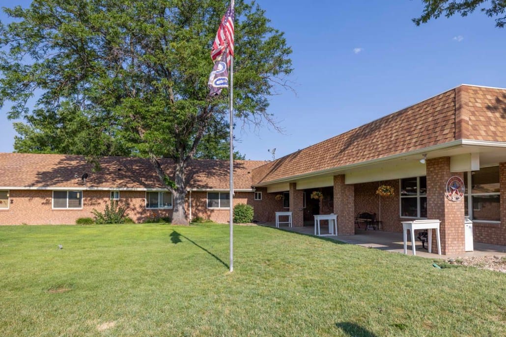 Exterior view of a senior living facility with flag