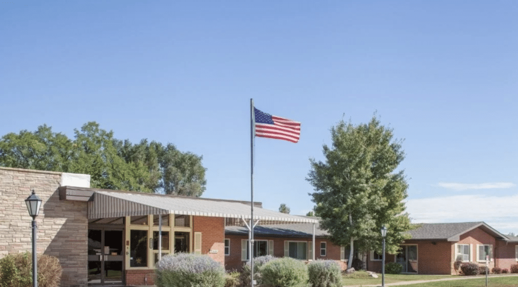 Exterior view of a senior living facility with flag