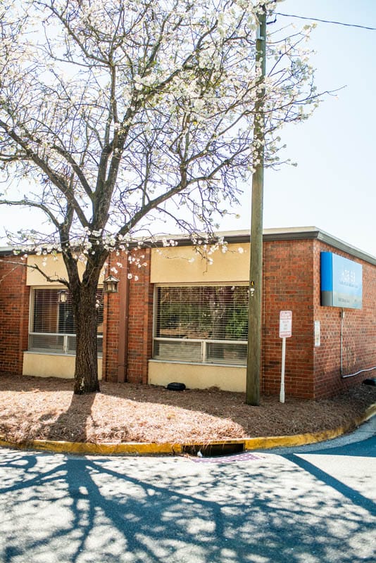 Exterior view of a nursing home building with a flowering tree