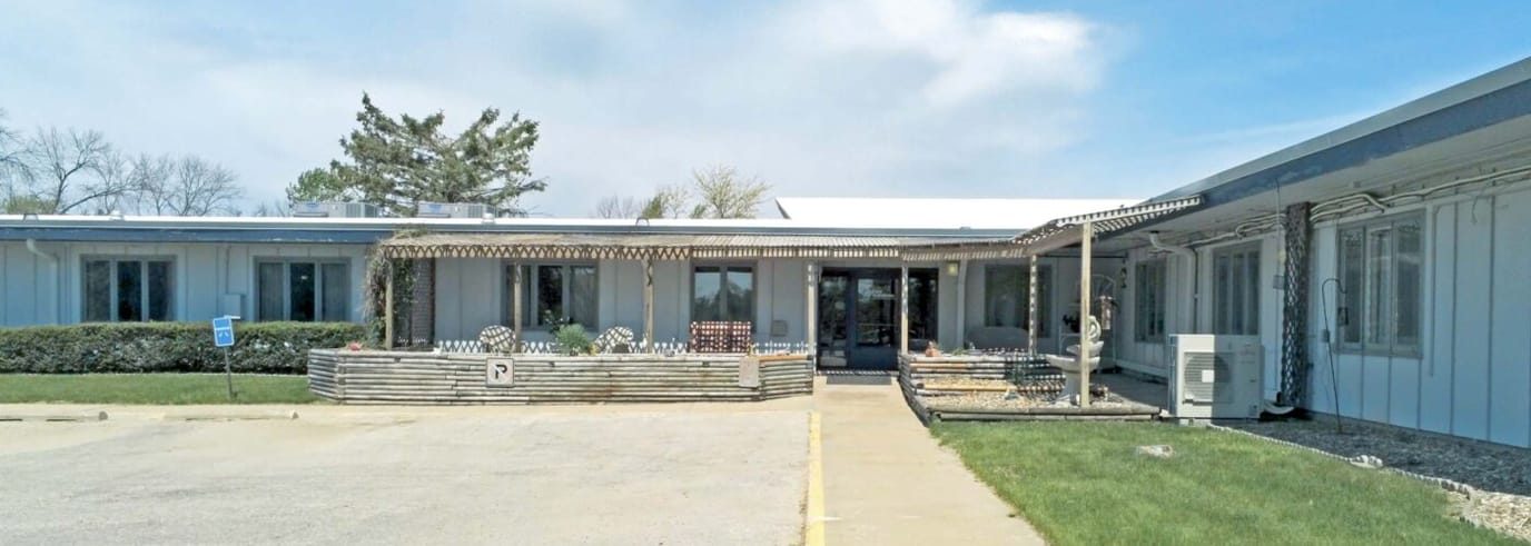 Exterior view of a senior living facility with gardens