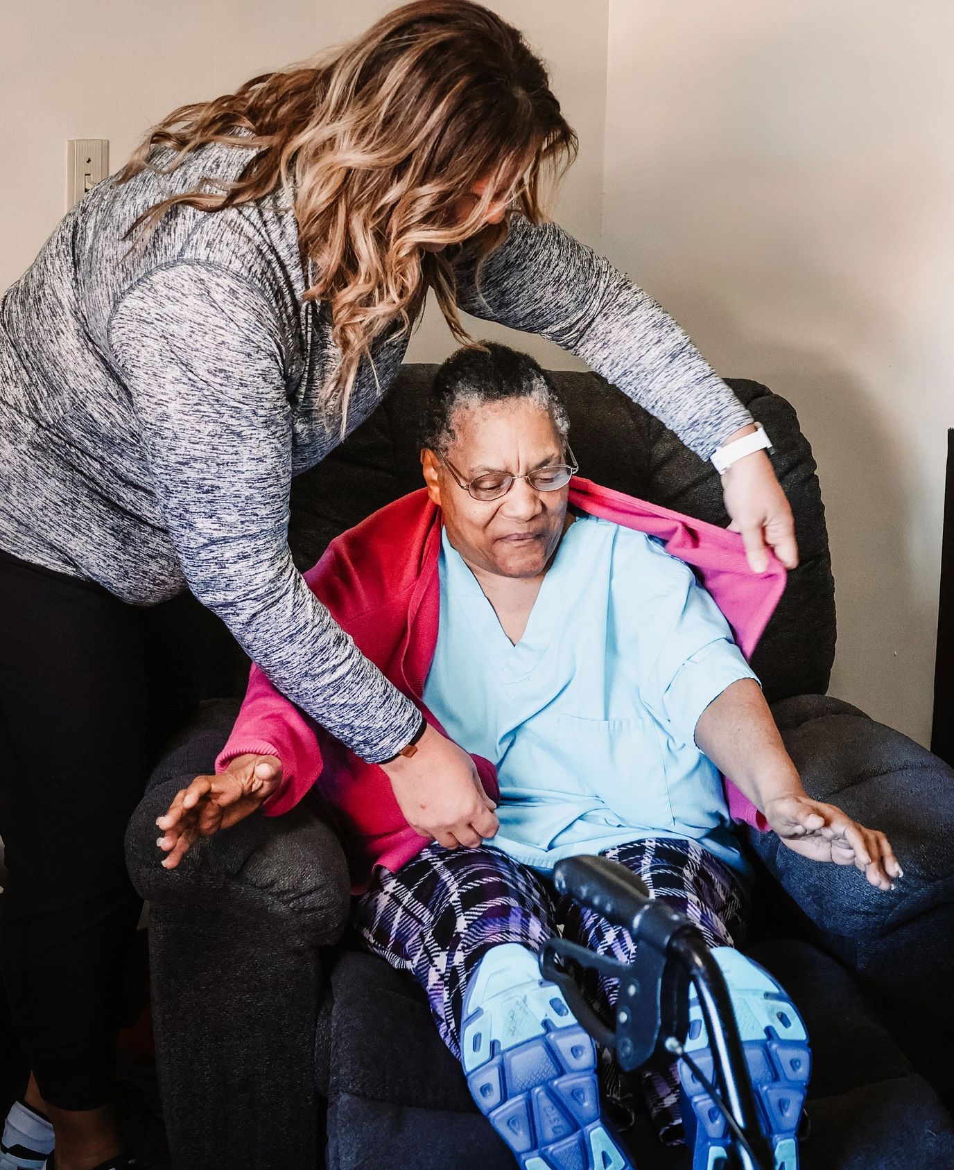 Caregiver assisting a resident in a cozy lounge