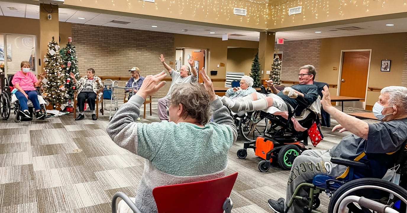 Residents participating in a seated exercise class indoors