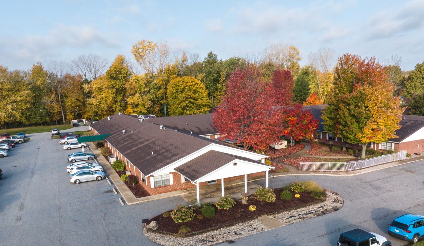 Aerial view of a senior living facility surrounded by autumn trees