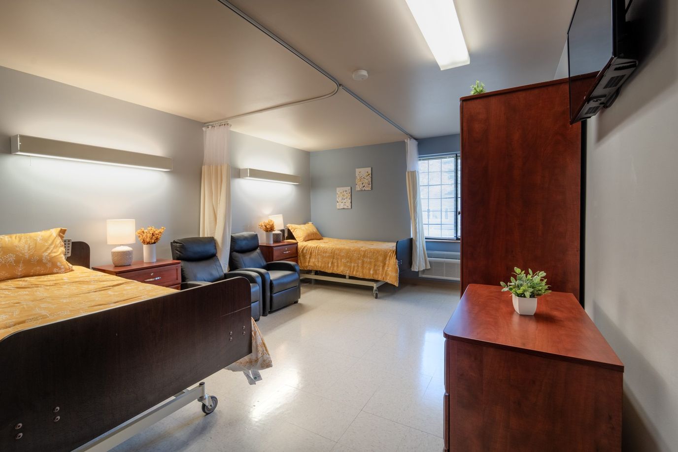 Bright shared resident room with two beds and a window