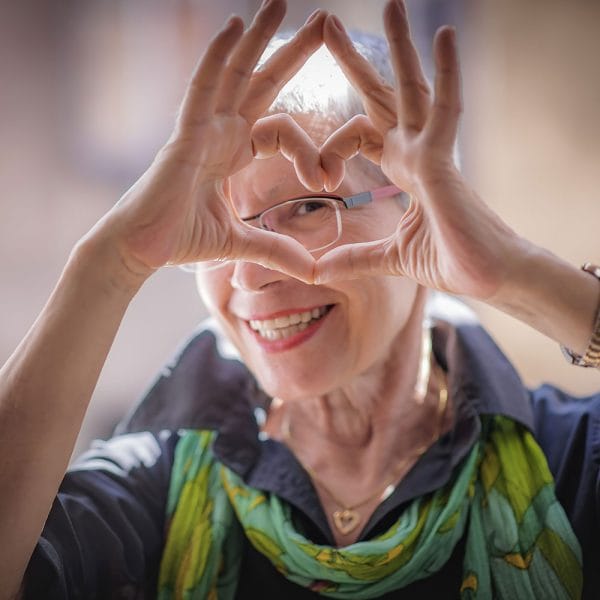 Envive of Lawrenceburg, Nursing Home in Lawrenceburg, IN — An elderly woman making a heart shape with her hands